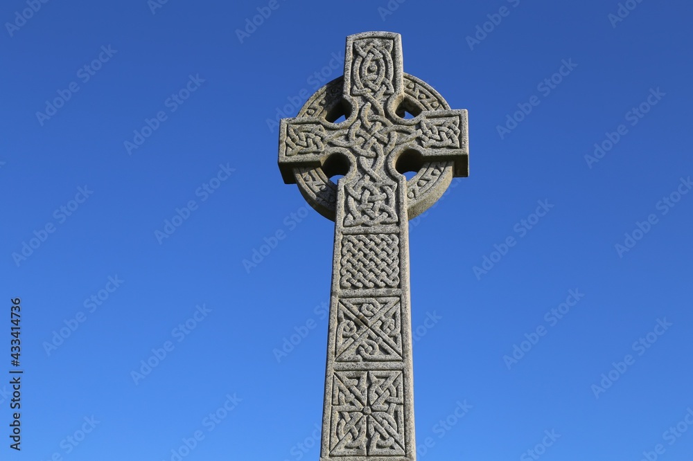 A closeup view of a Celtic Cross set against a bright, blue sky. A closeup view of a Celtic Cross set against a bright, blue sky.