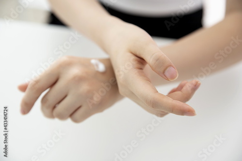 Young woman applying hand cream