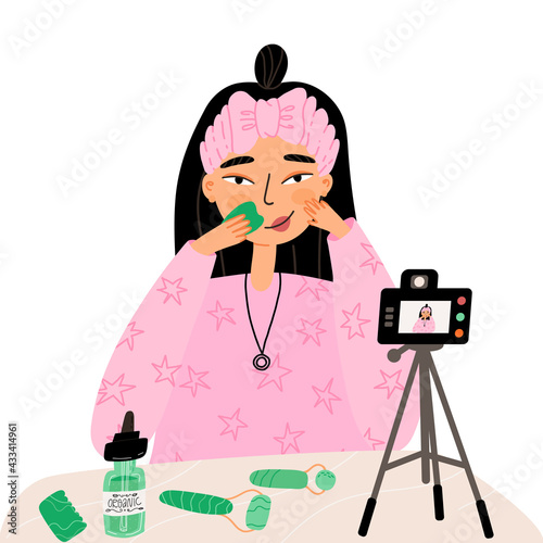 Blogger girl shows her beauty routine with gua sha scraper and face serum and record process on digital camera.
