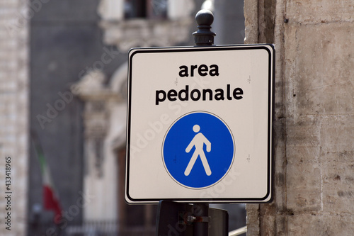 Cartello stradale che indica un'area pedonale e che vieta l'accesso alle auto, in piazza duomo a Catania con finestre barocche sfocate e bandiera italiana sullo sfondo photo