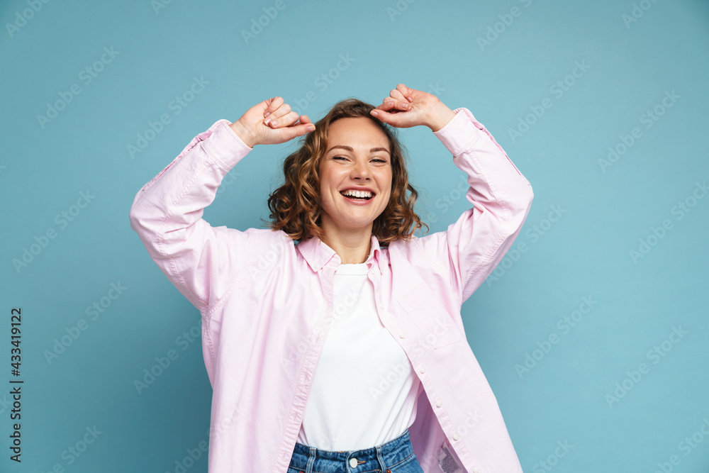 Young ginger woman laughing while dancing at camera Young ginger woman laughing while dancing at camera