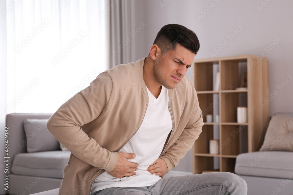 Man suffering from stomach ache at home. Food poisoning