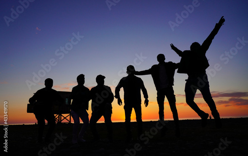 people jumping on the background of the sunset