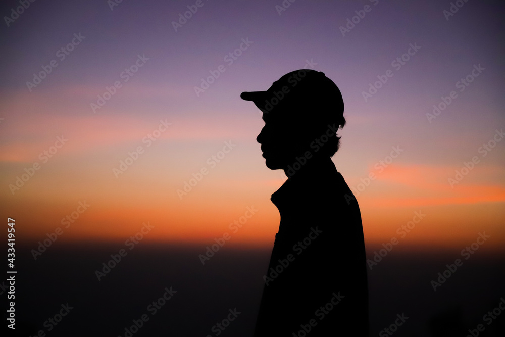 A young man is looking at the sunrise