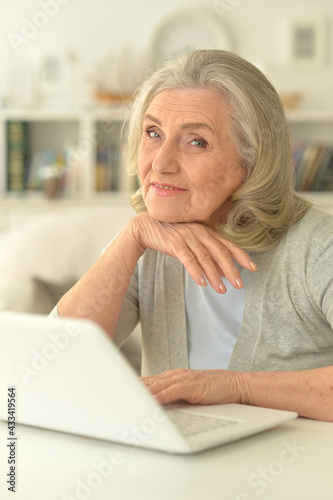 senior woman sitting at table with laptop