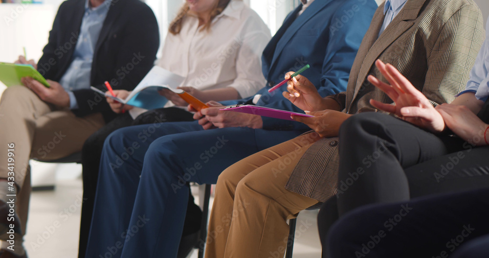 Fototapeta premium Cropped shot of diverse group of business people sitting in row in audience at business conference