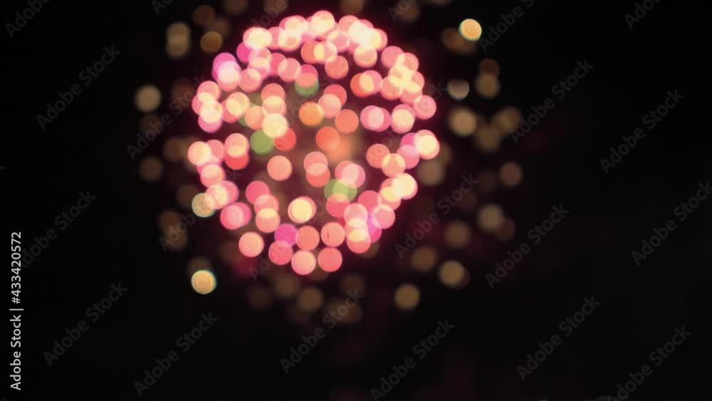Beautiful pink and lilac blurred motion background bokeh defocused fireworks at holiday night sky Blurry firework