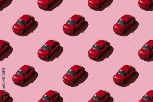 Red toy car seamless pattern on pink background. Trendy sunlight minimal concept.