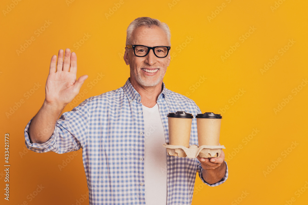 Grey haired senior man hold hot coffee beverage in takeaway mug Grey haired senior man hold hot coffee beverage in takeaway mug