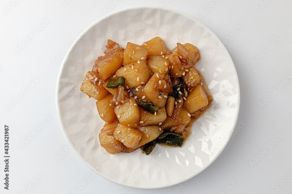 Simmered potatoes in soy sauce on a white background