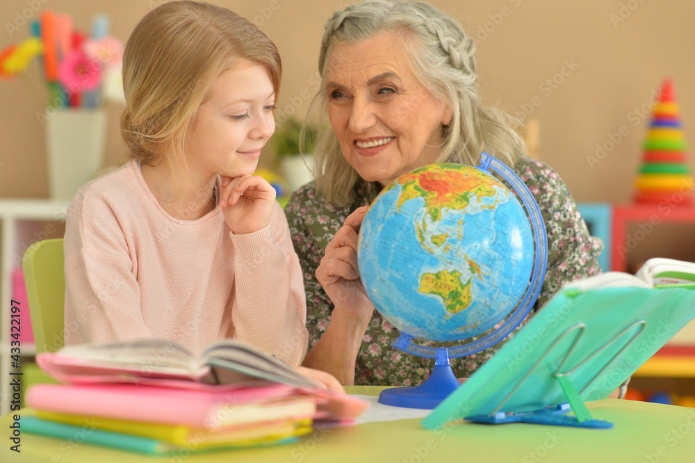 Grandmother with cute little girl doing homework Grandmother with cute little girl doing homework