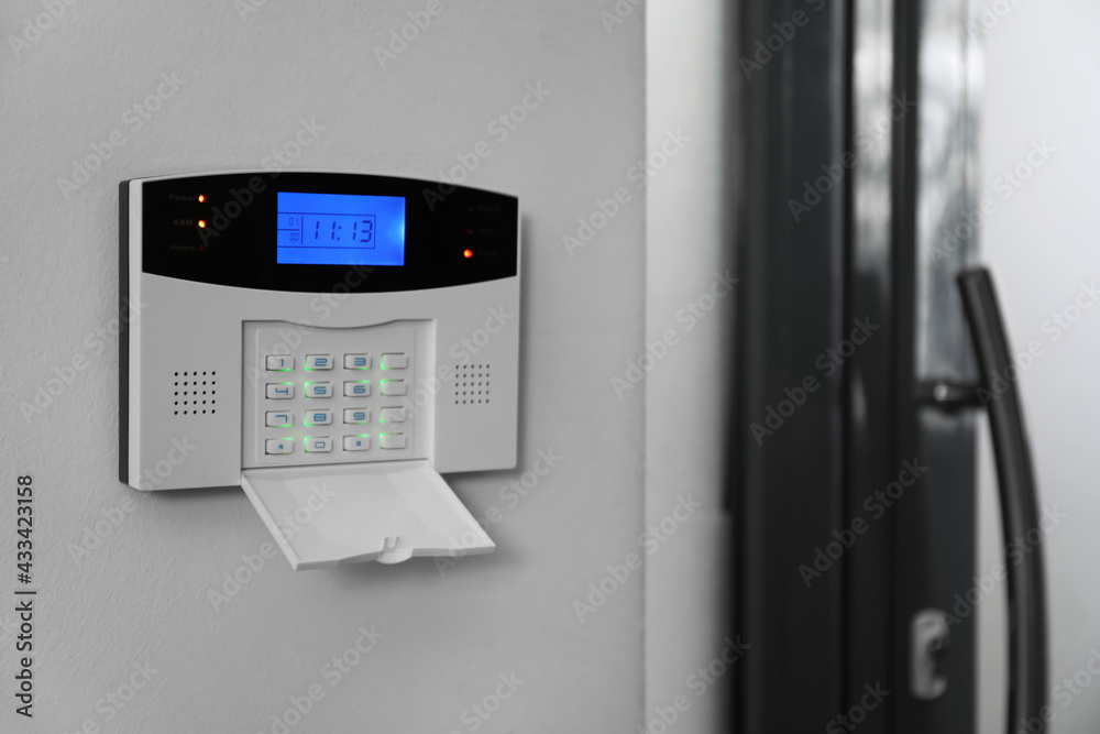 Home security system on white wall indoors, space for text Home security system on white wall indoors, space for text