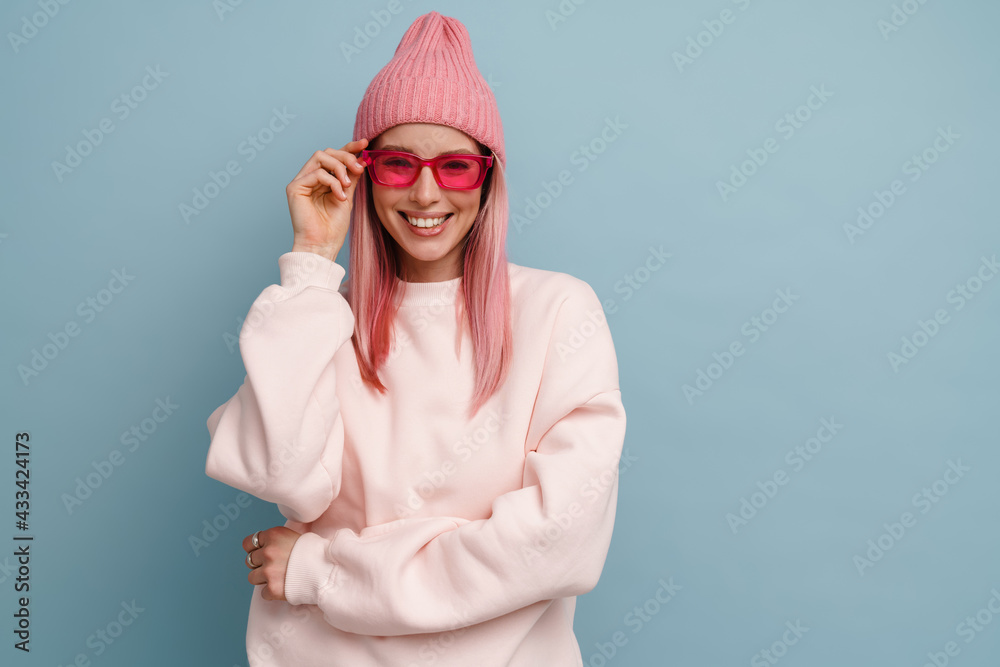 Young white woman with pink hair wearing sunglasses and smiling