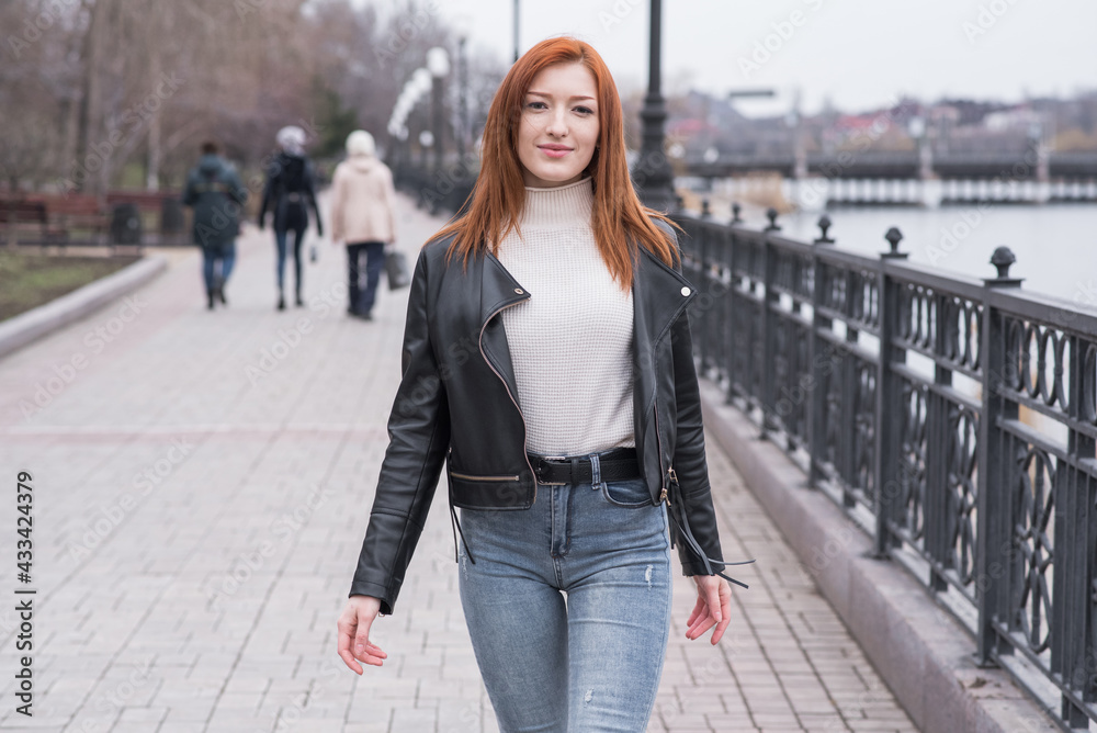 Portrait of a beautiful and positive redhead woman with clothes in grunge style. Posing while walking Portrait of a beautiful and positive redhead woman with clothes in grunge style. Posing while walking