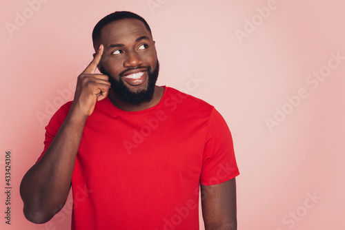 Handsome dark skin guy thinking looking aside copy-space isolated over pink background photo