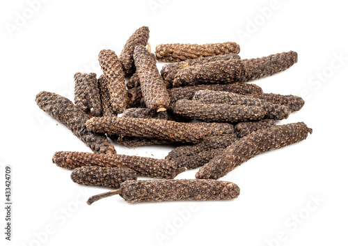 pile of java long pepper catkins closeup on white