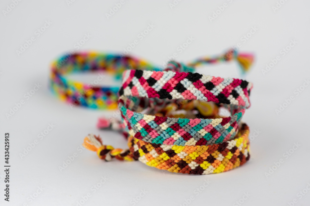 Fototapeta premium Group of handmade homemade colorful natural woven bracelets of friendship isolated on white background