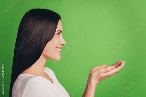 Portrait of girl hold hand empty space look aside isolated over green background