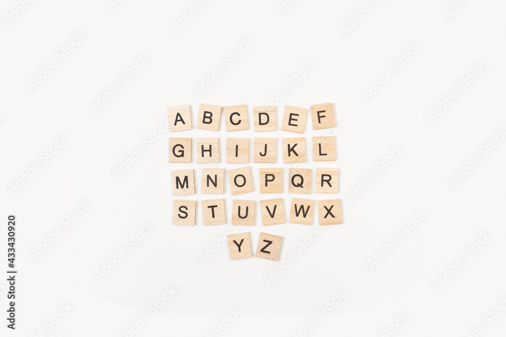 Letra completa de Scrabble alfabeto en mayúscula sobre fondo balnco liso y aislado. Vista superior. Copy space