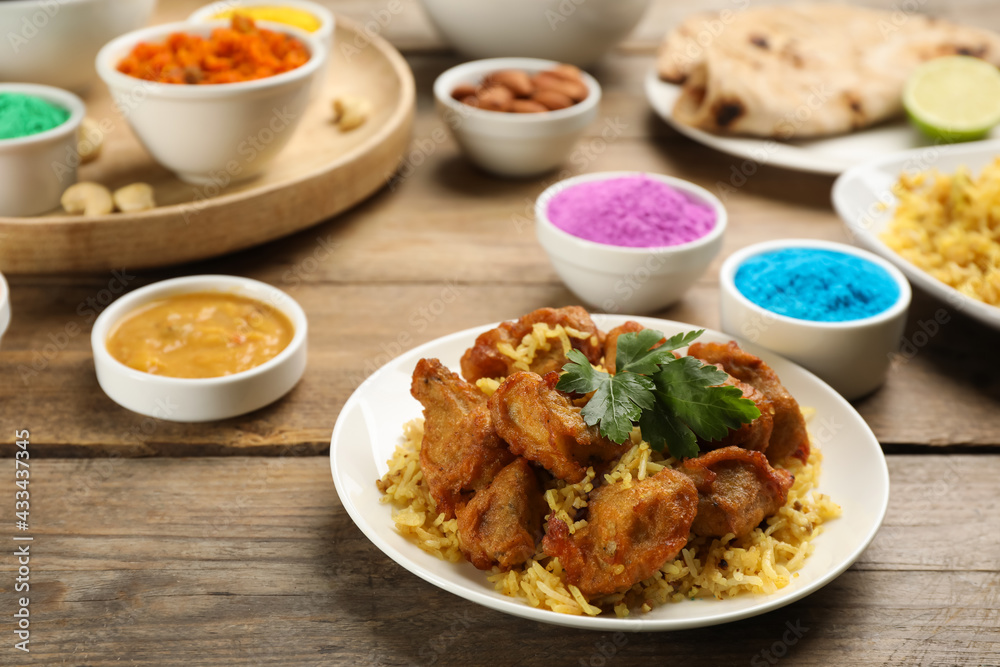 Traditional Indian food and color powders on wooden table. Holi festival celebration