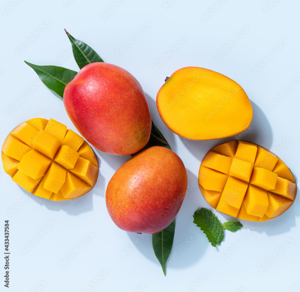 Mango design concept. Diced fresh mango fruit on blue table background. Mango design concept. Diced fresh mango fruit on blue table background.