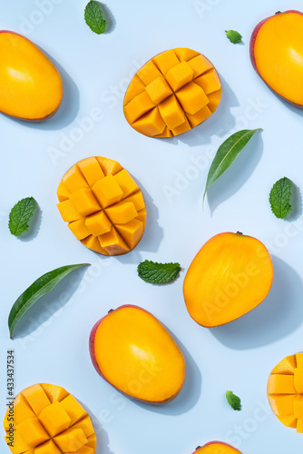 Obraz na płótnie Mango design concept. Diced fresh mango fruit on blue table background.