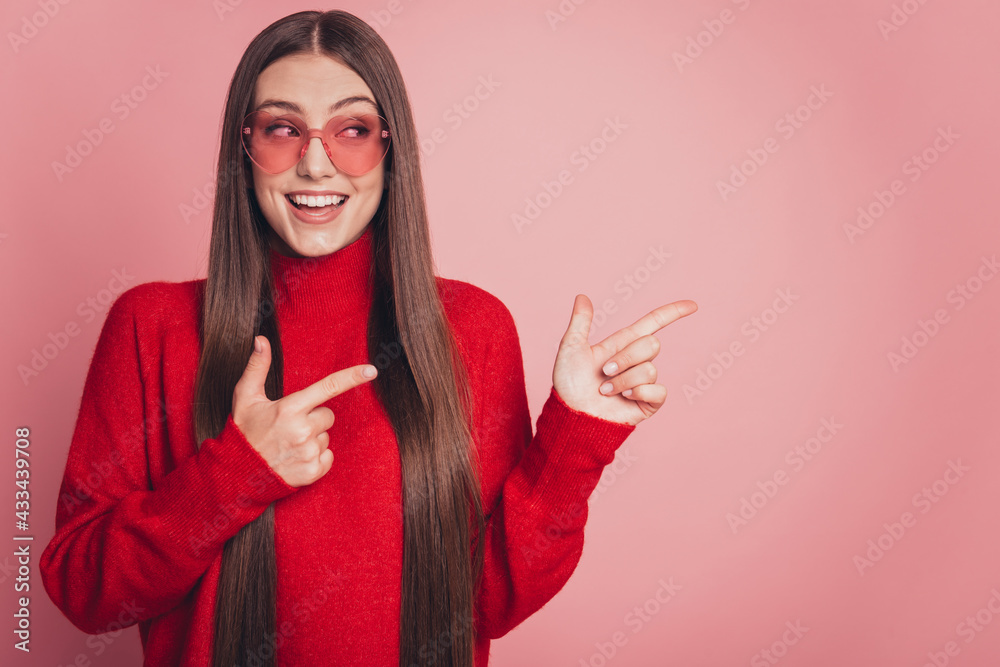 Portrait of positive girl promoter point index finger copyspace isolated pink color background Portrait of positive girl promoter point index finger copyspace isolated pink color background