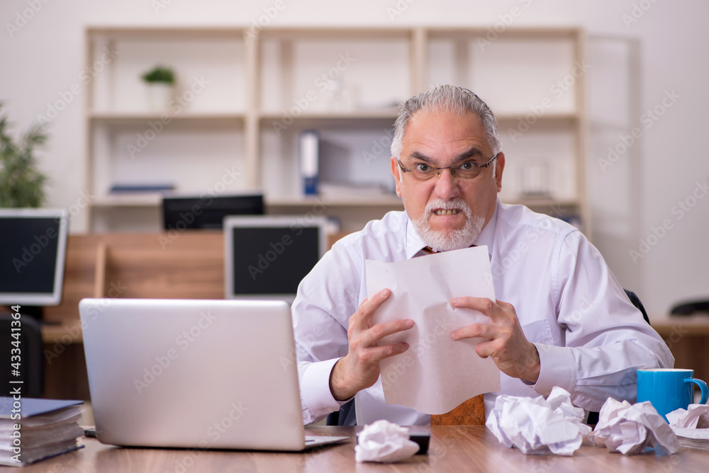 Old male employee in paper recycling concept Old male employee in paper recycling concept