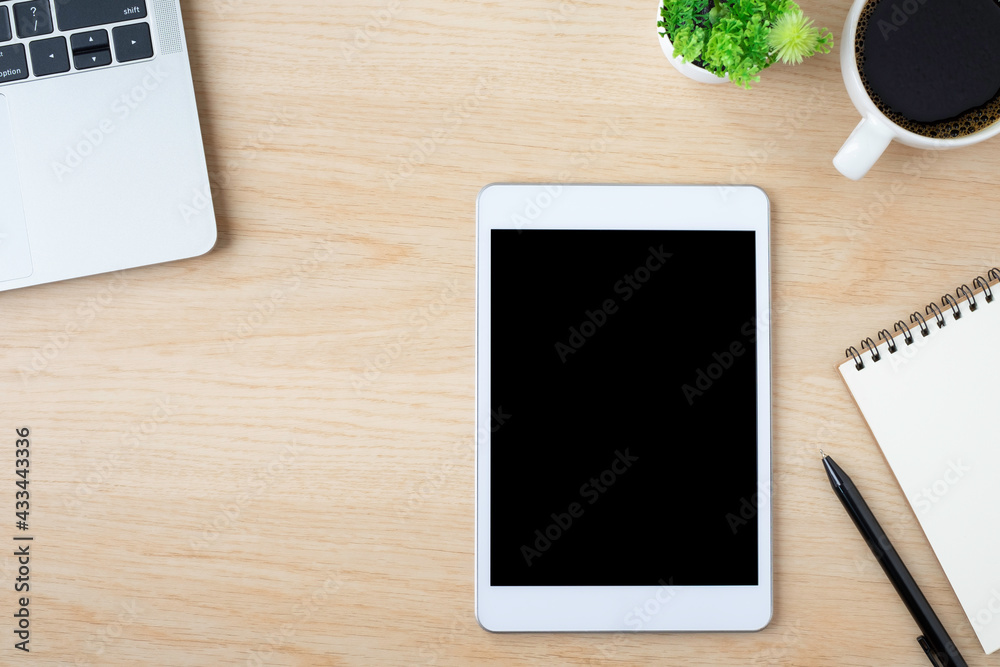 Top view above of tablet blank monitor black screen on wood office desk table with notebook, laptop, coffee cup. Workspace, office business technology. Education and business concept. flat lay Top view above of tablet blank monitor black screen on wood office desk table with notebook, laptop, coffee cup. Workspace, office business technology. Education and business concept. flat lay
