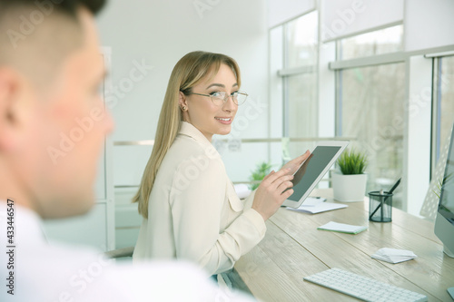 Young woman flirting with her colleague during work in office. Cheating concept