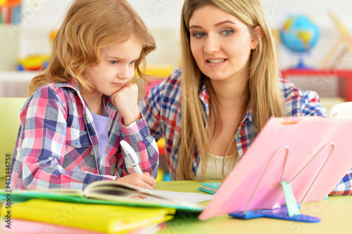 Mother and daughter doing homework together in room