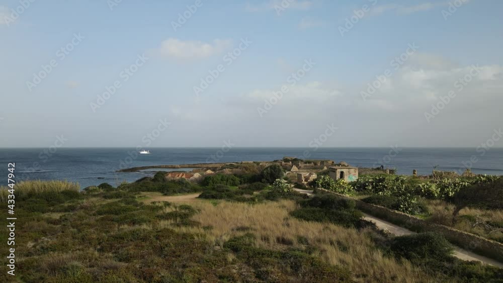 Drone flies up from the ground and flies above the natural marine reserve Plemmirio in province of Siracusa (Syracuse) in Sicily. Aerial view of seaside