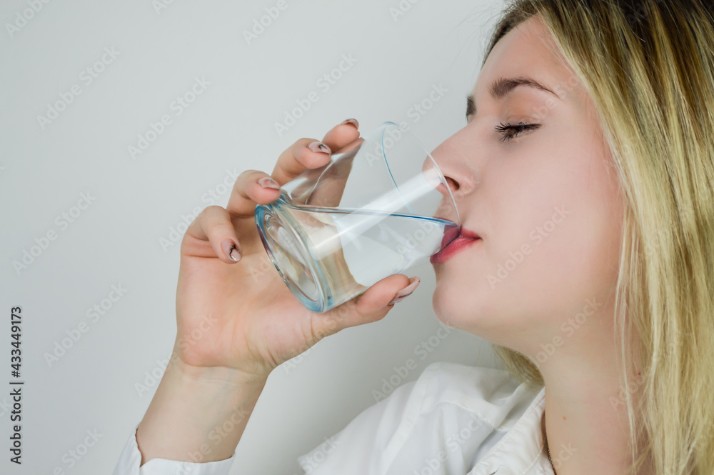 Portrait of a beautiful young blonde woman drinking a glass of water Portrait of a beautiful young blonde woman drinking a glass of water
