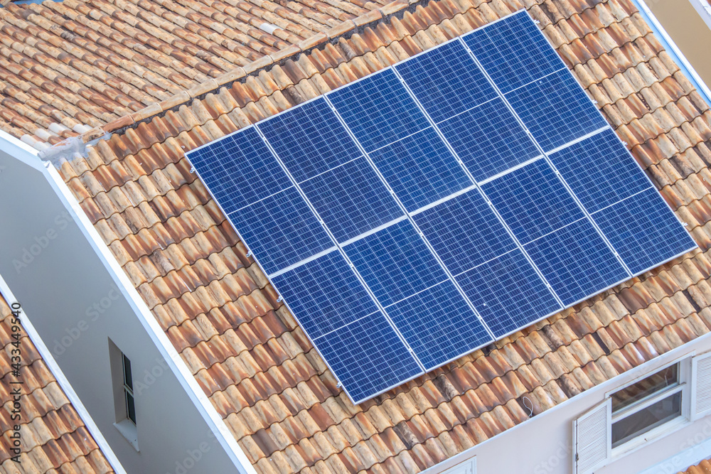 Painéis solares no telhado de uma casa. Economia de energia, meio ambiente e energia renovável. - obrazy, fototapety, plakaty 