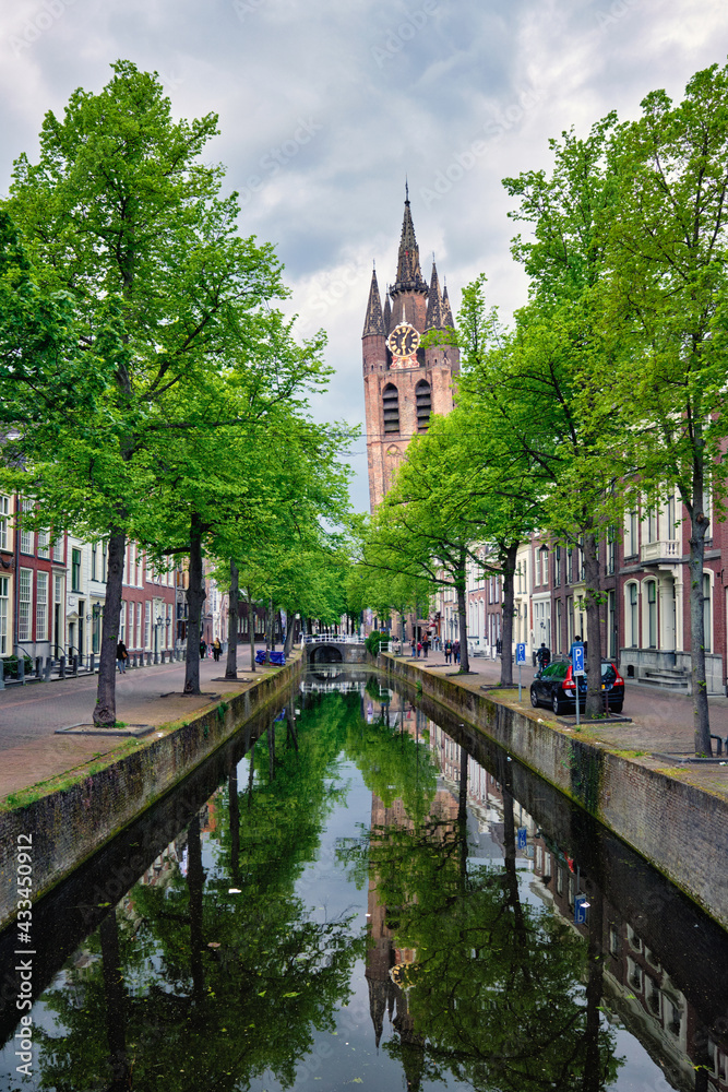Naklejka premium Delt canal with bicycles and cars parked along. Delft, Netherlands