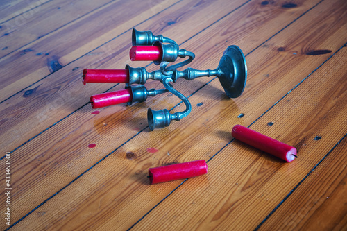 Quadro em tela tin candleholder with red candles fallen on wooden floor