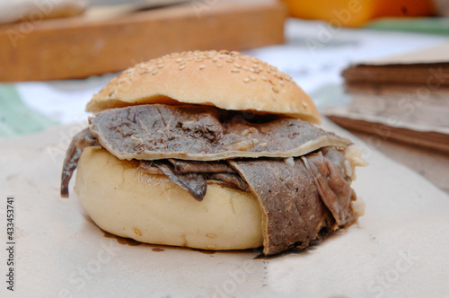 Pane ca meusa that is a sicilian traditional sandwich made whit bread and stewed spleen and alittle bit of fresh lemon. Palermo Sicily, Vucciria market street food.  photo