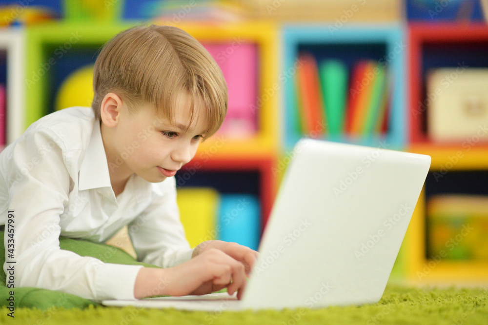 exited boy using laptop while lying on floor exited boy using laptop while lying on floor