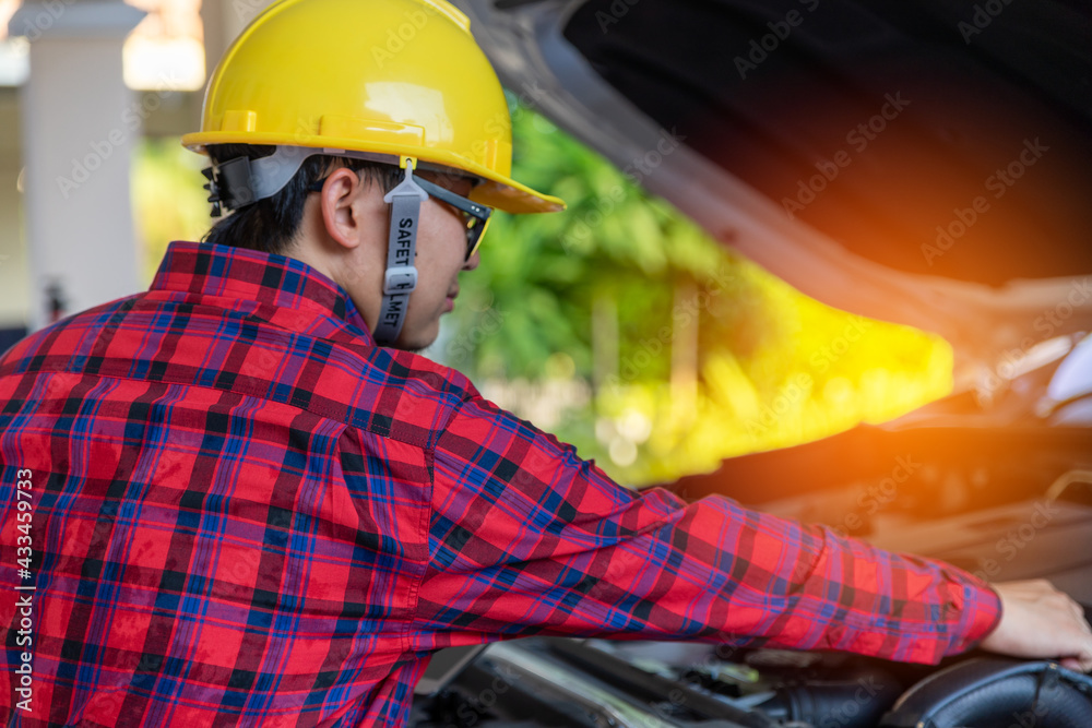 Asian engineer holding digital tablet. mechanic in uniform Check Car problem. Checking engine with tablet. 5 Generation wireless technology.