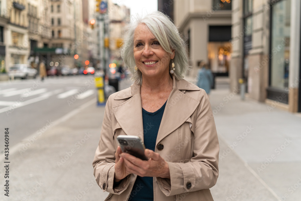 Mature caucasian woman in city walking street using cellhpone Mature caucasian woman in city walking street using cellhpone