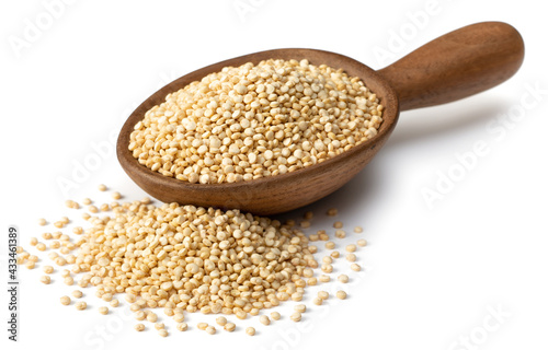raw white quinoa in the wooden spoon, isolated on white background