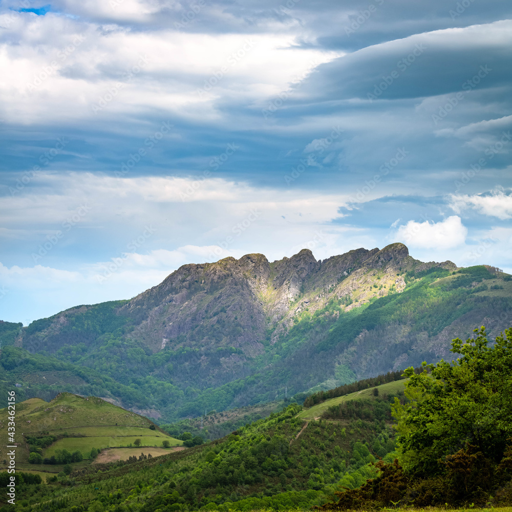 Naklejka premium Green vivid mountains covered with threatening stormy clouds