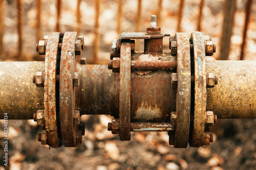 Fragments of old large gas pipe. Rusty brown curved metal iron pipe.