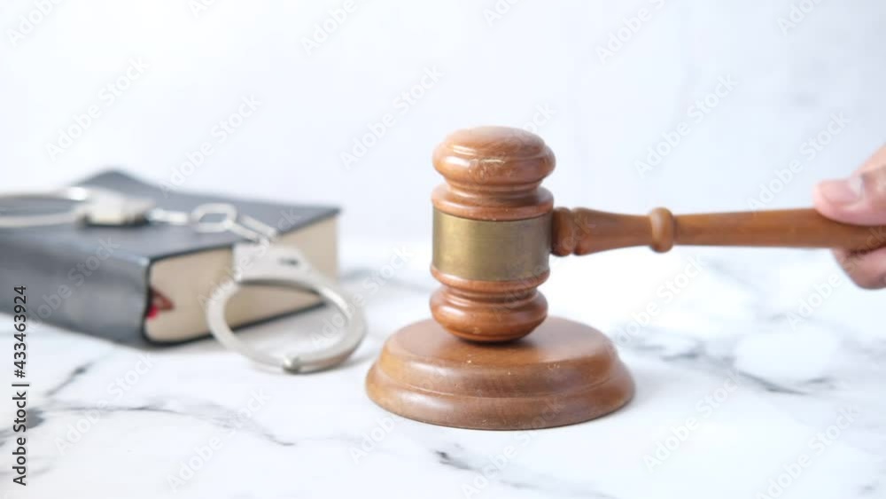  person's hand striking the gavel.