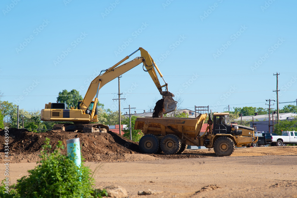An excavator loads a truck with earth An excavator loads a truck with earth