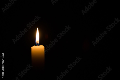 candle burning on black background. concept of faith, memory, prayer, commemoration