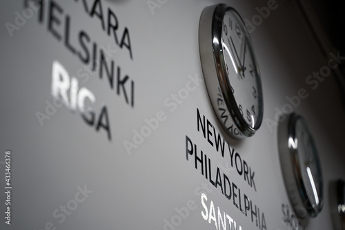 Obraz na płótnie Many wall clocks on the white wall of business office showing time of different cities of the world w salonie