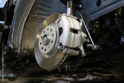 Brake disc and brake caliper installed on a modern car. Car service and spare parts.