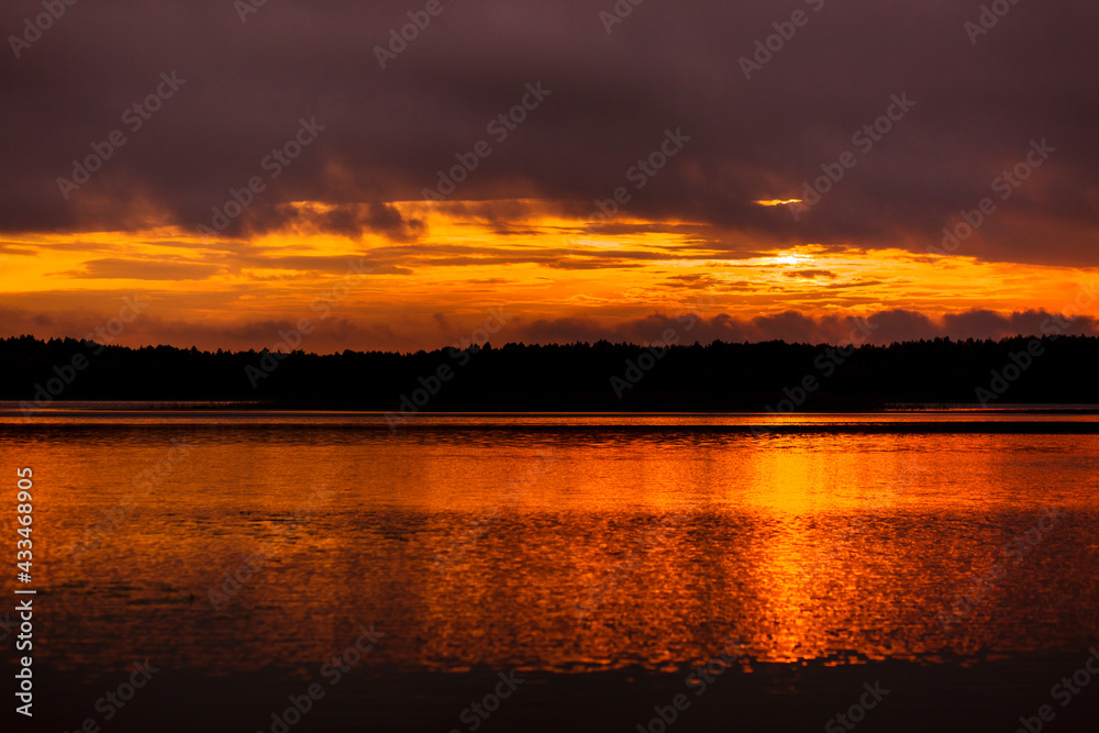 Beautiful sunset on the lake among the trees