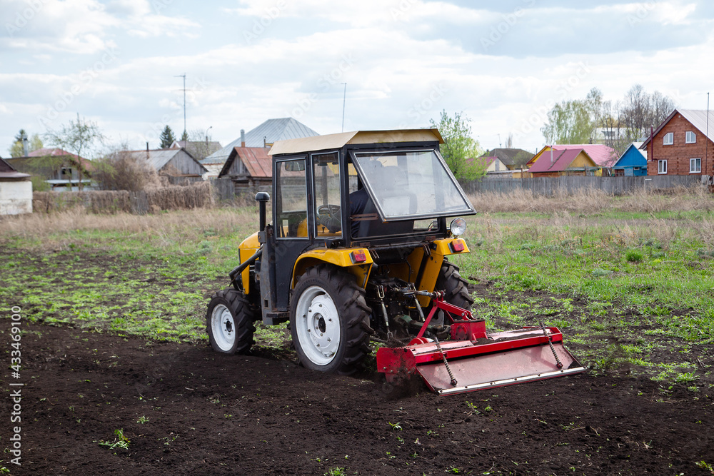 spring plowing the field on a mini tractor